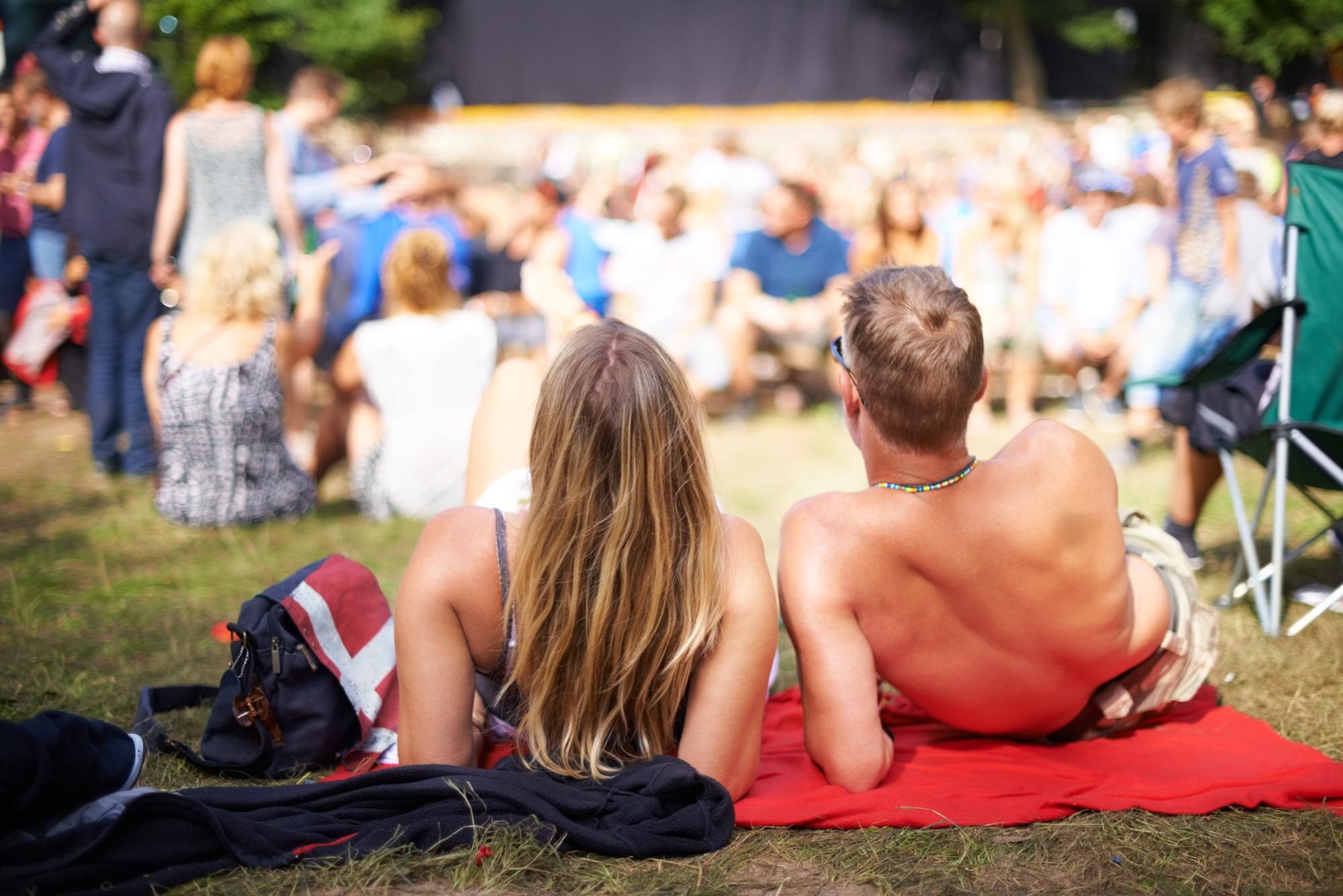 Yleisö nauttii maksuttomasta puistokonsertista kesäpäivänä.